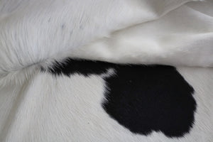 white and black cowhide rug